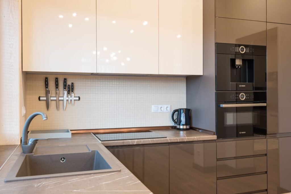 Modern kitchen design with built-in wall coffee machine, wall ovens, and cooktop for appliance repair live oak.